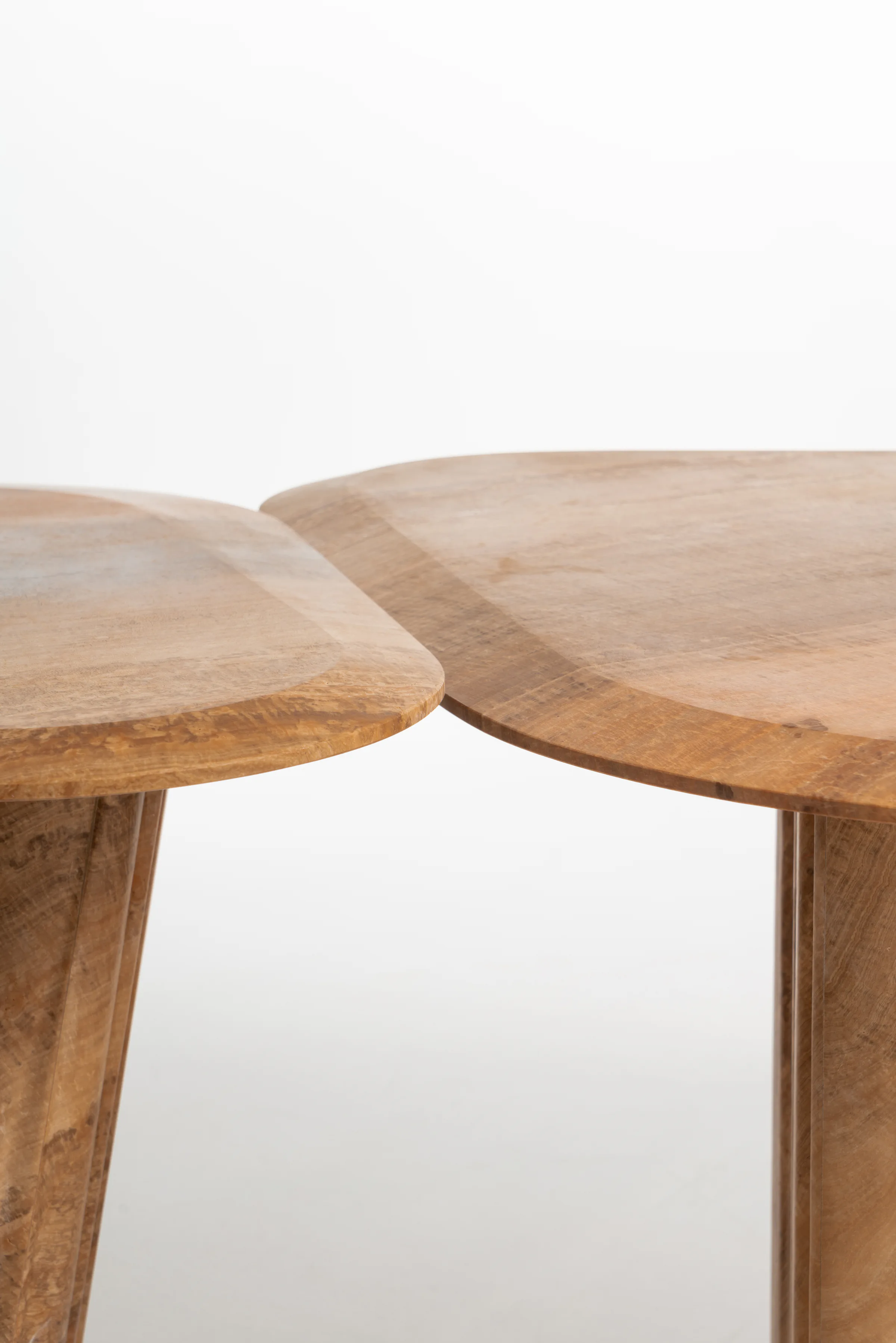 Curved edges of two Wave stone tabletops