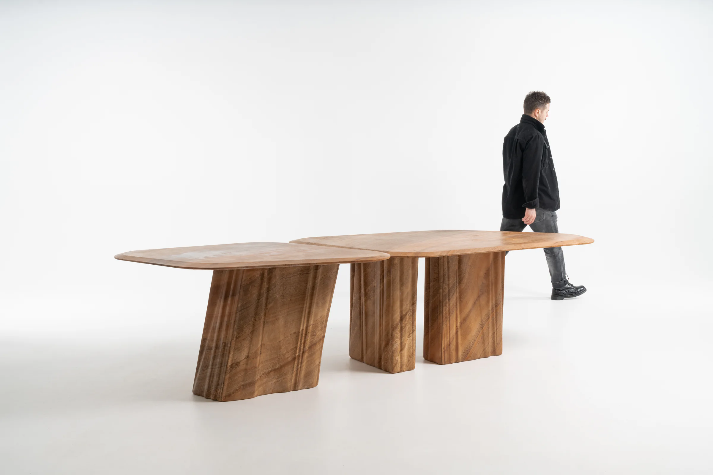 Wave dining tables with a person alongside for scale