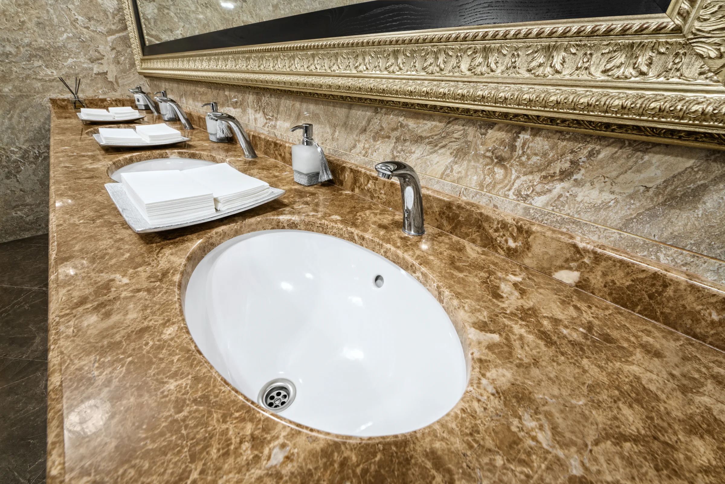 Brown stone vanity surface beneath the basins