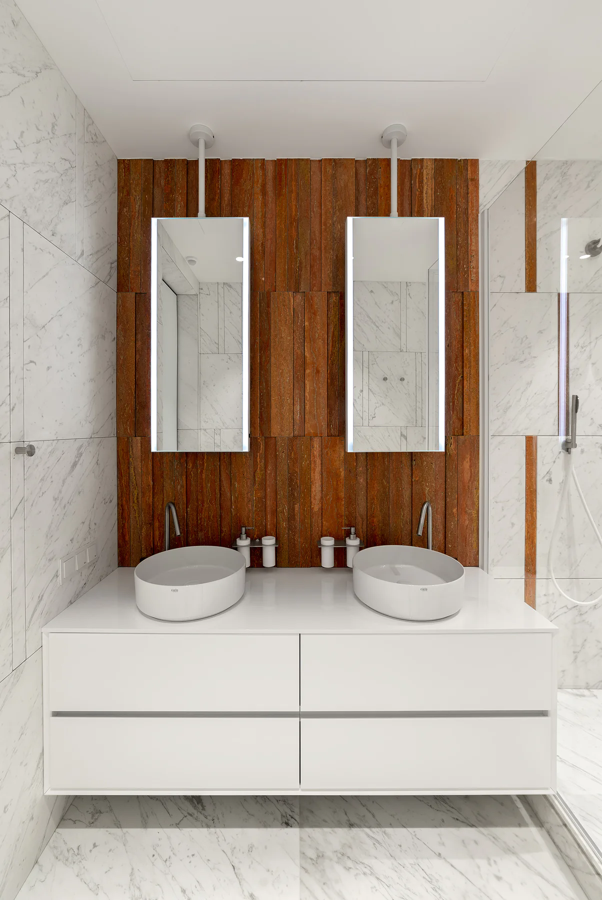Light stone walls and floor beside the double vanity
