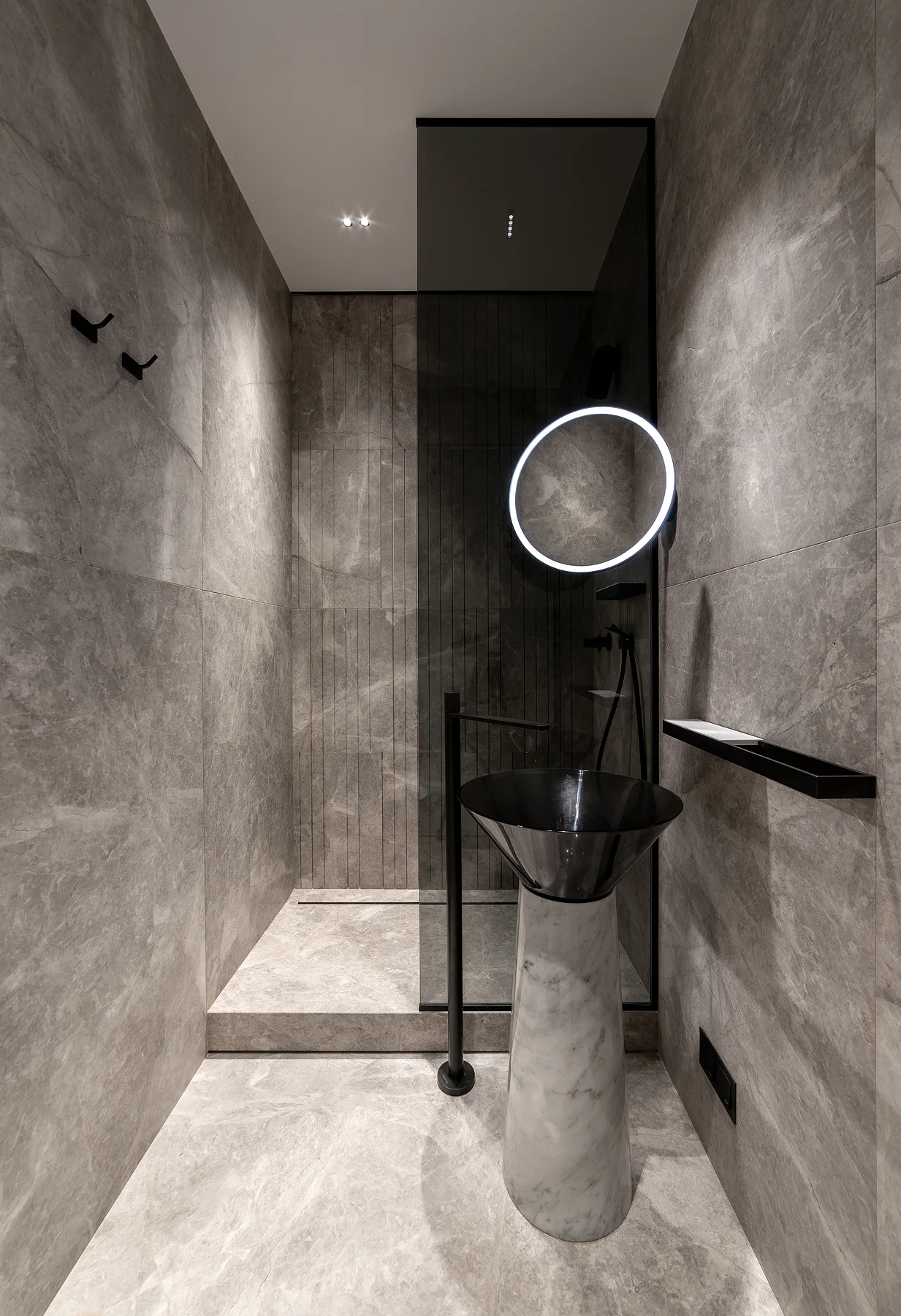 Sculptural stone basin against grey stone walls
